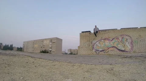 Young man practicing jumps and flips at the roof of building Stock Footage 67315804