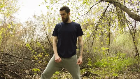 Young man practicing karate in the spring forest. Stockbeeldmateriaal 80694634