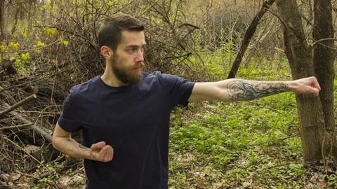 Young man practicing karate in the spring forest. Vídeo Stock 80698868
