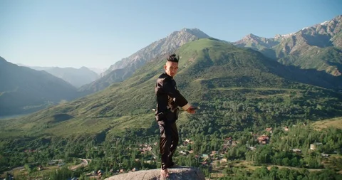Young man practicing kung fu with sword. Tai Chi at the top of the mountain Stock Footage 116716305