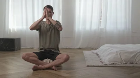 Young man practicing mindful breathing meditation at home. Calming breathwork Stock Footage 311048389