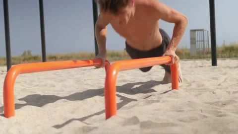 Young man practicing push-ups on parallel bars. Stock Footage 161431957