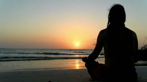 Young man practicing relaxation exercises by the sea Stock Footage 94126995