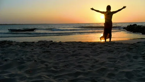 Young man practicing relaxation exercises by the sea Stock Footage 94127220