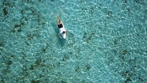 Young man is practicing surfing and swimming in the open sea, the ocean in good  Stock Footage 96311641