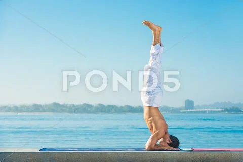 Young Man Practicing Upside Down Yoga Position At Pacific Beach, San Diego,