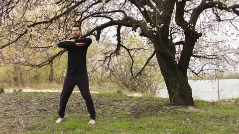 Young man practicing wing chun near the river 스톡 동영상 80691561