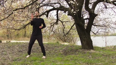 Young man practicing wing chun near the river Video stock 80691615