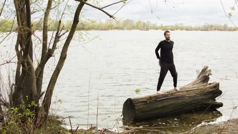 Young man practicing wing chun near the river 스톡 동영상 80702925
