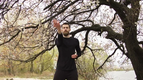 Young man practicing wing chun near the river Video stock 80731038
