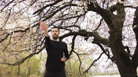 Young man practicing wing chun near the river Stockbeeldmateriaal 80732445