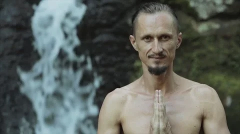 Young man practicing yoga fitness exercises outdoors on a jungle background. Stock Footage 68963953