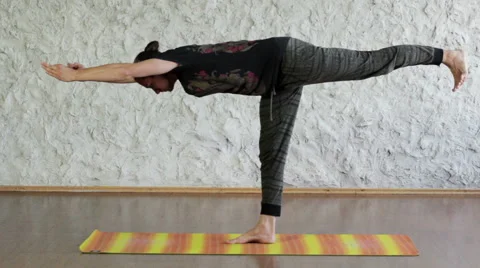 The young man practicing yoga in the hall. Warrior pose. HD Stockbeeldmateriaal 65405080