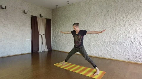 The young man practicing yoga in the hall. The standing pose. 4K Stock Footage 66301041