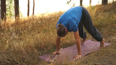 Young man practicing yoga ln the wood. Upward facing dog Stock Footage 80675925
