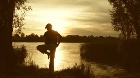 Young man practicing yoga near the river Video stock 79577917