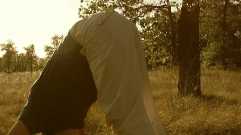 Young man practicing yoga in a summer forest. Video stock 79548018