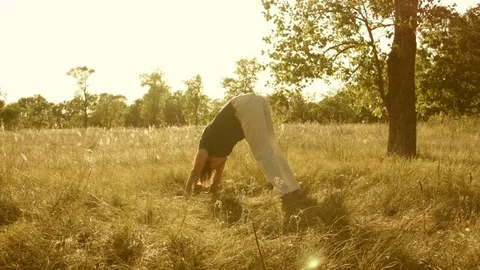 Young man practicing yoga in a summer forest. Vídeos de archivo 79574287