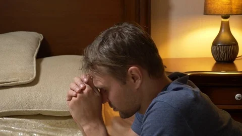 The young man prays before going to sleep. 4k Stock-Footage 83200300