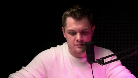 Young man prepare for live broadcast in radio studio, put down phone, puts on Stock Footage 248262485