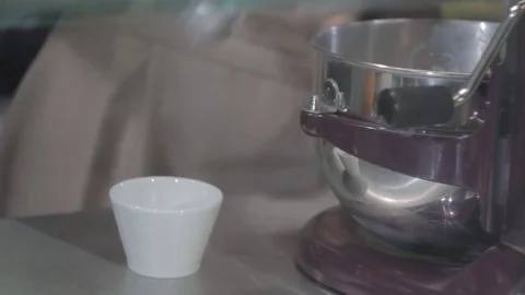 A young man, prepares ice cream, from a spoon into a glass, a ball,  a cook.  Stock Footage 74868985