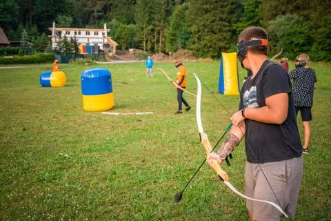 Young man preparing for an attack while playing archery tag Stock Photos