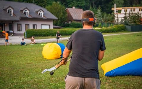 Young man preparing for an attack while playing archery tag Stock Photos