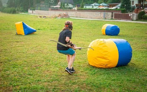 Young man preparing for an attack while playing archery tag Stock Photos