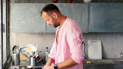 Young man preparing breakfast in the kitchen Stock Footage 82171956