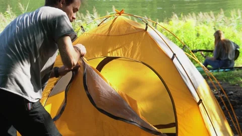 Young man preparing camping tent Stock Footage 247034801