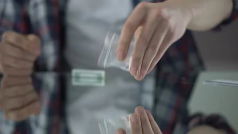 Young man preparing cocaine to snort it through rolled-up dollar, drug addiction Stock Footage