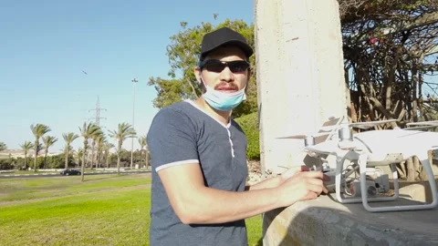 Young man preparing to fly a drone, outside the city. Stock Footage 133354536