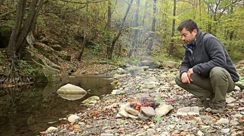 Young man Preparing food steaks and sausages on camping fire. Vidéo 56882185