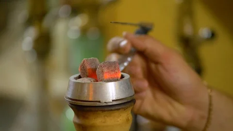 The young man is preparing a hookah. Lifted the bowl with coals. Stock Footage 124731697