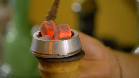 The young man is preparing a hookah. puts the bowl with coals. Stock Footage 124731723