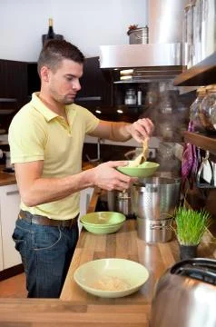 Young man preparing lunch in kitchen Stock Photos
