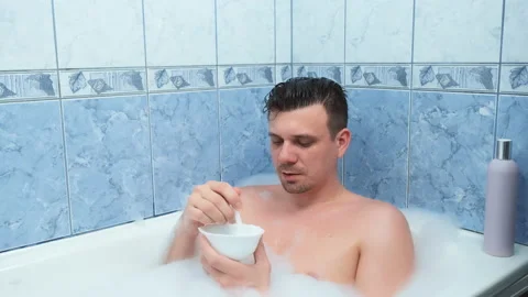 Young man is preparing mixing alginate mask lying in bathroom with foam at home. Video stock 158842861