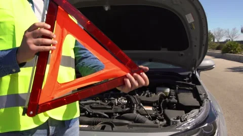 Young man preparing a red triangle to warn other road users, car breakdown stop Stock Footage 171534469