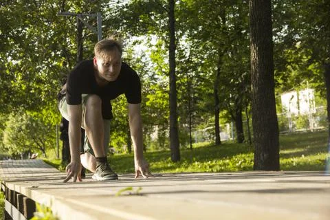 A young man is preparing for a run. The man is preparing to run from a low st Stock Photos
