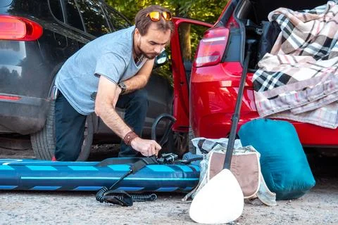 Young man preparing sup board for riding Stock Photos
