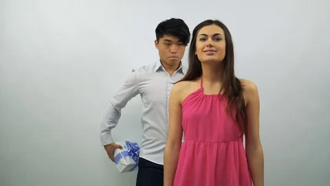 Young man presents gift box to girl on a white background Stock-Footage 71444413