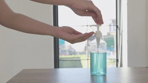 Young man presses a bottle of alcohol, Seventy percent alcohol-based gel is u Stock Footage 147537164
