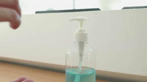 Young man presses a bottle of alcohol, Seventy percent alcohol-based gel is u Stock Footage 147537296