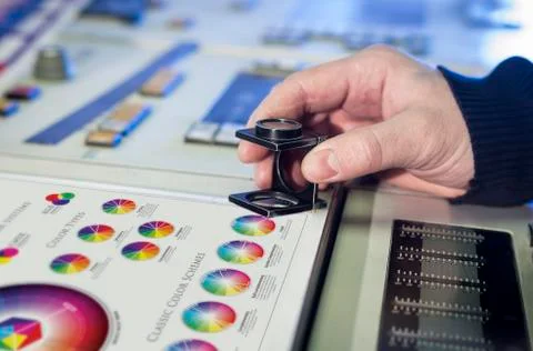 Young man in the process of offset printing and color correction Stock Photos