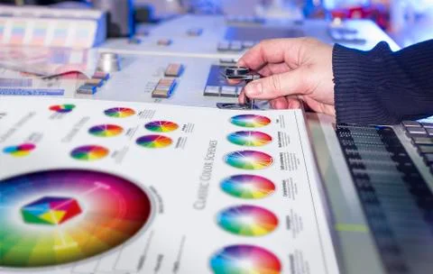 Young man in the process of offset printing and color correction Stock Photos