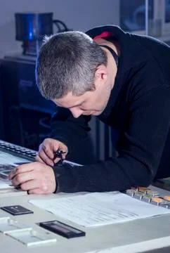 Young man in the process of offset printing and color correction Stock Photos