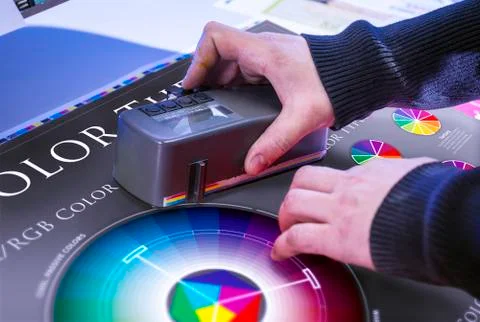 Young man in the process of offset printing and color correction Stock Photos