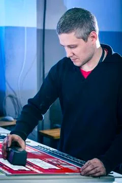 Young man in the process of offset printing and color correction Stock Photos