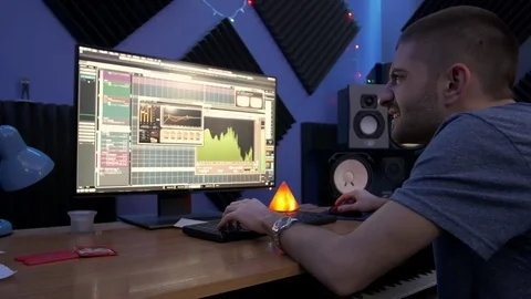 Young man producing music in studio Stock Footage 84087686