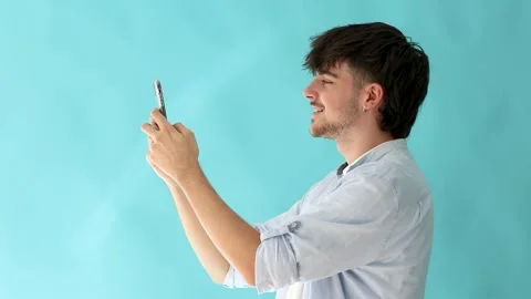 Young man in profile isolated on background typing on mobile phone or smartph Stock Footage 255708643